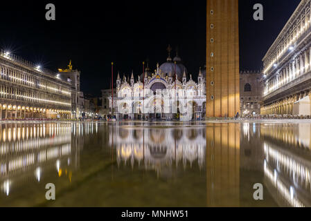 Basilica in San Marco square in Venice with reflection at night during the high tide, or aqua alta, that flooded the square with sea water Stock Photo