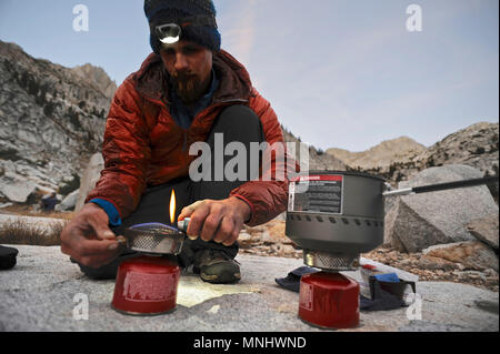 Backpackers prepare dinner by headlamp at Laurel Lake on a two-week trek of the Sierra High Route in the John Muir Wilderness in California. The 200-mile route roughly parallels the popular John Muir Trail through the Sierra Nevada Range of California from Kings Canyon National Park to Yosemite National Park. Stock Photo