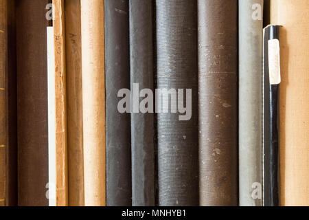 Many old dusty books in a library on a wooden shelve Stock Photo