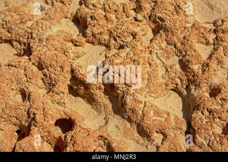 Background of light brown eroded volcanic rocks on a rocky beach at Barragem de Montargil, Portalegre, portugal Stock Photo