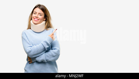 Young injured woman wearing neck brace collar pointing away side with finger Stock Photo