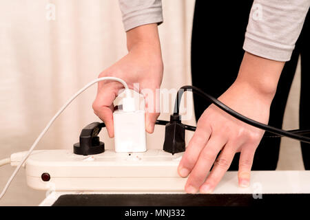 women hand putting the electric plug on the electricity supply connection Stock Photo