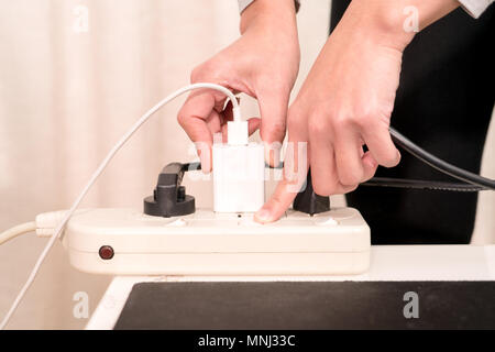 women hand putting the electric plug while switching on the electricity supply connection Stock Photo