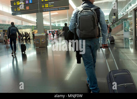 passengers with luggage walking through the shopping areas at barcelona airport departure lounge Stock Photo