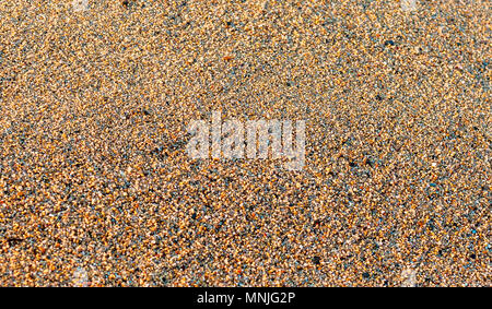 Closeup of sunny beach sand. Multicolor coarse sand background. Selective focus Stock Photo