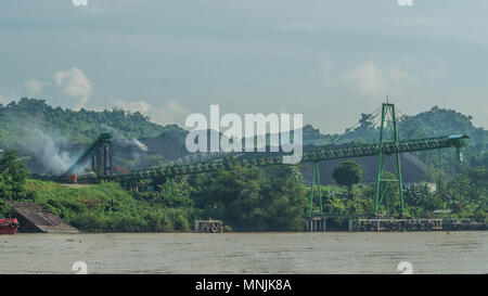 coal stockpile with conveyor on Mahakam riverbank, Indonesia Stock Photo