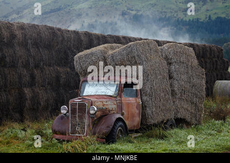 Vintage Commer truck with hay bales, Hawea Flat, near Wanaka, Otago, South Island, New Zealand Stock Photo