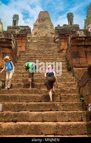 Tourists climbing up the steep steps to reach the central sanctuary of Pre Rup temple with its five towers arranged in a quincunx. Stock Photo
