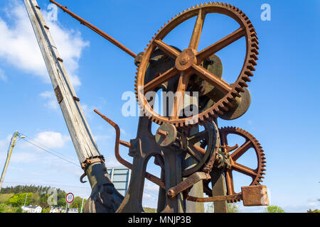 cast iron crane with wooden jib or boom showing the original hand turned cast iron gearing, gear wheels, gear teeth, cogs and drive shaft. Stock Photo