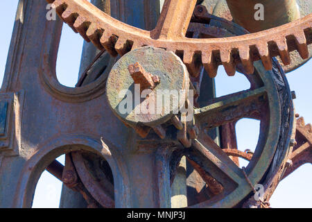 cast iron gantry crane with wooden jib or boom showing the original hand turned cast iron gearing, gear wheels, gear teeth, cogs and drive shaft. Stock Photo