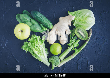 Heart shape from green vegetables and fruits. Black background. Creative concept for love clean eating. Diet, health, vegetarian food. Spring detox. H Stock Photo