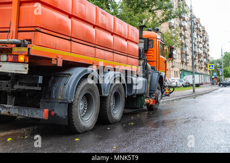 Street flusher machines are on the road with streams of water up, close-up Stock Photo