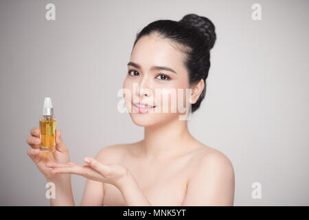 Beauty concept. Asian pretty woman with perfect skin holding oil bottle Stock Photo