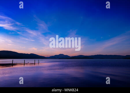 Loch Lomond sunset, vivid colors reflecting in the tranquil loch Stock Photo