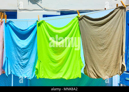 T-shirts of different colours dry outdoor on sunny day Stock Photo
