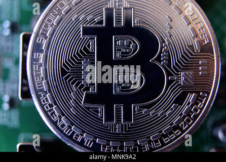 Silver souvenir coin Bitcoin on computer circuit board background. Stock Photo