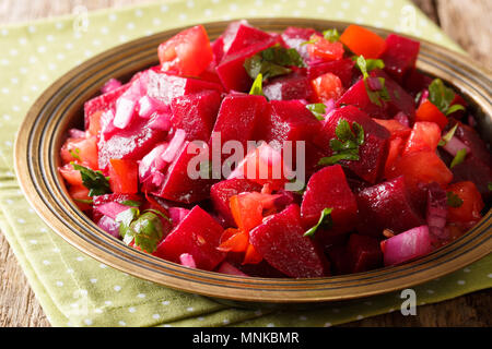 Delicious salad from boiled beets with onions, tomatoes and herbs with olive oil close-up on a plate. horizontal Stock Photo