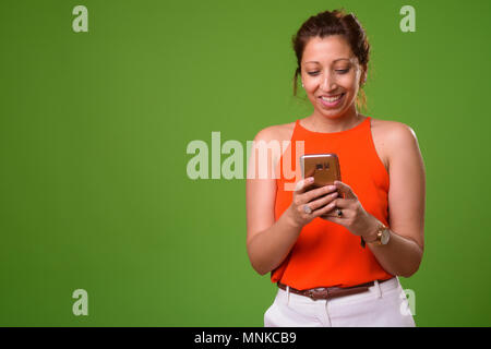 Beautiful businesswoman against green background Stock Photo