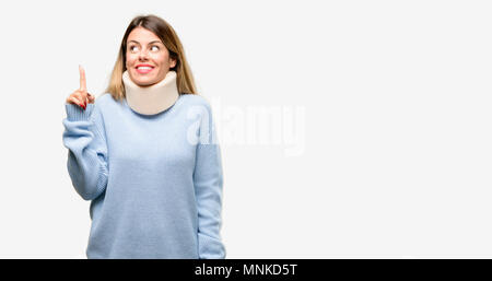 Young injured woman wearing neck brace collar raising finger, the number one Stock Photo