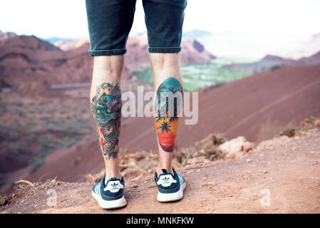 coloured calf tattoos on male boy looking at the scenery at cafayate argentina mnkfkw