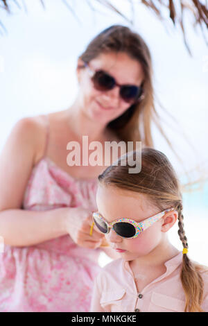 Young woman brushing her daughter's hair Stock Photo