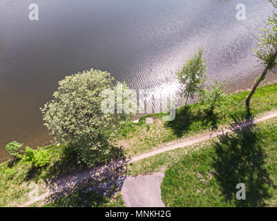 aerial drone landscape view. foot path on pond coast during bright summer day Stock Photo