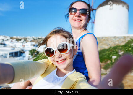 Happy family mother and her adorable little daughter on vacation taking selfie at Little Venice area on Mykonos island, Greece Stock Photo