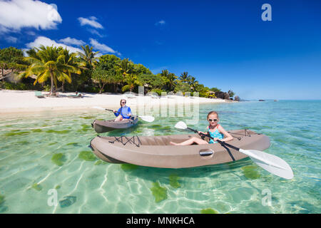 Family og mother and daughter paddling on kayaks at tropical ocean water during summer vacation Stock Photo