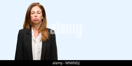 Middle age woman wearing jacket with sleepy expression, being overworked and tired isolated blue background Stock Photo