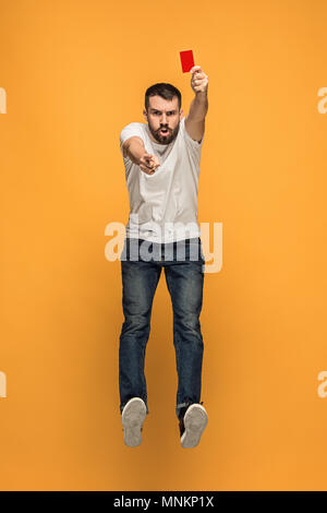 Football supporter with red card on orange background Stock Photo