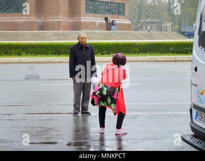 Berlin, Germany - April 14, 2018: Asian tourists take photos against the base of Victory Column in Berlin Stock Photo
