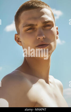 Guy with black scarf and wind on sky background in dessert Stock Photo