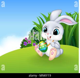 Cute Easter Bunny painting an egg on the Meadow background Stock Vector