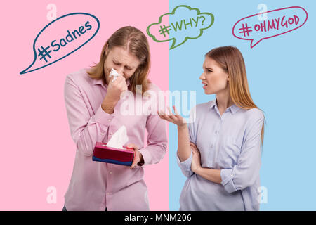 Irritated woman frowning while talking to her crying husband Stock Photo