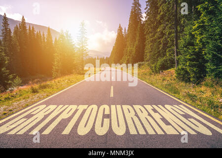 Cryptocurrency word written on road in the mountains Stock Photo