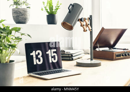 Close-up on a bright and natural workspace with laptop and an old-fashioned record player in a modern apartment interior Stock Photo