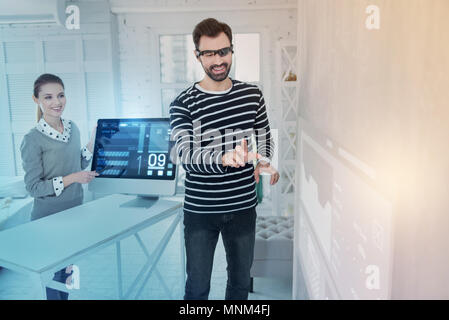 Cheerful web developer wearing virtual reality glasses and smiling Stock Photo