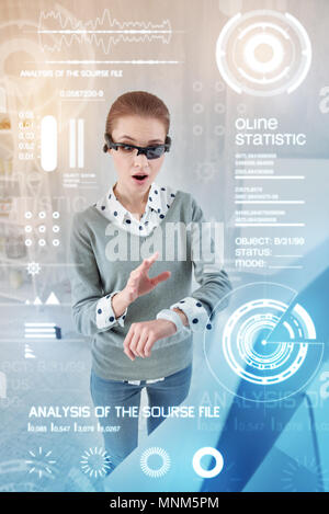 Emotional woman feeling excited while using her smart watch Stock Photo