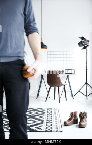 White flat with desk, lamp, male shoes lying on floor Stock Photo