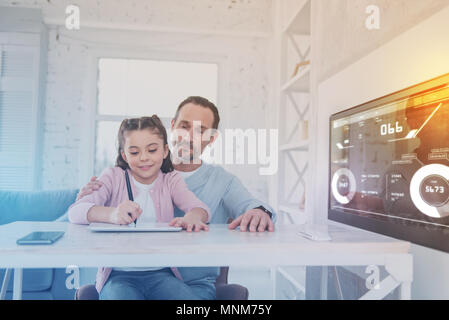 Clever girl doing homework and her father helping Stock Photo