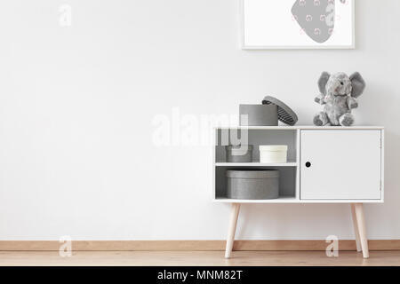 Carton round boxes standing on white wooden cupboard with stuffed toy Stock Photo