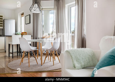 New flat with round table, white chairs and open kitchen