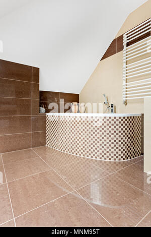 Modern bathroom with brown tiling and mosaic tile bathtub Stock Photo