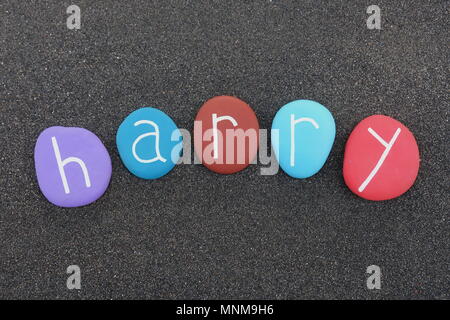 Harry, masculine given name with multicolored stones over black volcanic sand Stock Photo