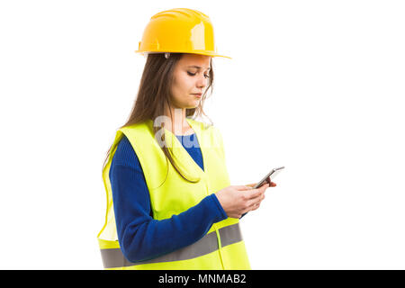 Young female architect or engineer texting on smartphone as technology communication concept isolated on white background Stock Photo