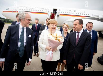 18 May 2018, Russia, Sochi: Chancellor of Germany Angela Merkel (Christian Democratic Union) is received by Krasnodar's Governor Weniamin Iwanowitz Kodratjew (R) and the German ambassador in Russia, Ruediger Freiherr von Fritsch (L) at the International Airport in Sochi. Subsequently Chancellor Merkel will pass by Russian President Vladimir Putin's summer residence for a working visit. Topics of discussion will be international conflicts like Ukraine, Syria, the Middle East and Iran. Photo: Kay Nietfeld/dpa Credit: dpa picture alliance/Alamy Live News Stock Photo