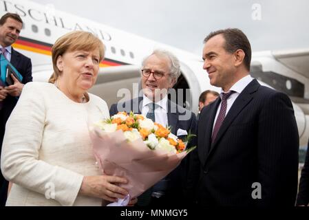 18 May 2018, Russia, Sochi: Chancellor of Germany Angela Merkel (Christian Democratic Union) is received by Krasnodar's Governor Weniamin Iwanowitz Kodratjew (R) and the German ambassador in Russia, Ruediger Freiherr von Fritsch (C) at the International Airport in Sochi. Subsequently Chancellor Merkel will pass by Russian President Vladimir Putin's summer residence for a working visit. Topics of discussion will be international conflicts like Ukraine, Syria, the Middle East and Iran. Photo: Kay Nietfeld/dpa Credit: dpa picture alliance/Alamy Live News Stock Photo