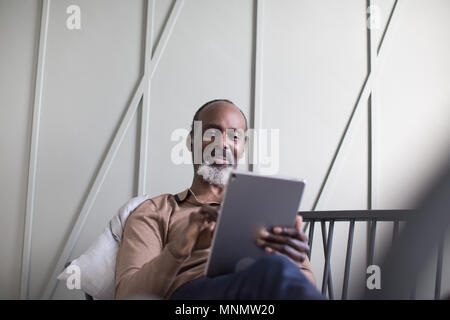 African American senior male using digital tablet Stock Photo