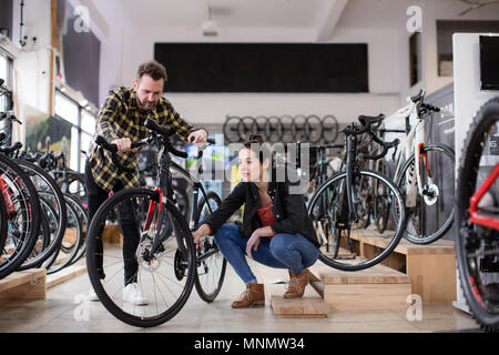 Small business owner helping customer in a bike store Stock Photo