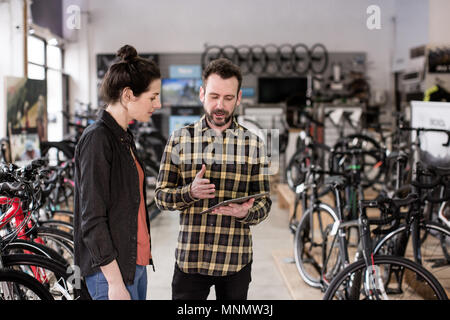 Small business owner serving customer in a bike store Stock Photo